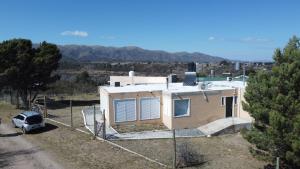 a house with a car parked in front of it at Sierras de Paz in Villa Giardino