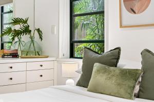 a bedroom with a bed with green pillows and a window at Byron Getaway @the Crest in Byron Bay +23 photos