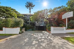 a driveway leading to a house with a palm tree at Byron Getaway @the Crest in Byron Bay