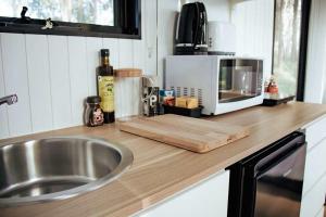 um balcão de cozinha com pia e micro-ondas em Solitary Islands Farm 2 by Tiny Away em Arrawarra