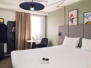 une chambre d'hôtel avec un lit et une table dans l'établissement ibis Saint-Nazaire - Trignac, à Trignac