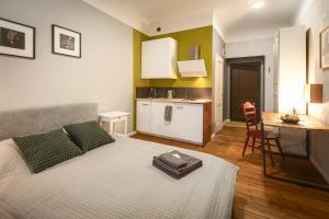 a room with a bed and a kitchen with a table at Baltic Design Apartments with free Parking and self check in in Rīga +28 photos