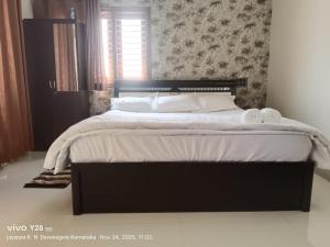 Ένα ή περισσότερα κρεβάτια σε δωμάτιο στο Aakruthi Homestay