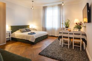 a bedroom with a bed and a table in it at Baltic Design Apartments with free Parking and self check in in Riga