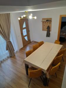 a dining room with a wooden table and chairs at Casa de Vacanta Gea in Şugag