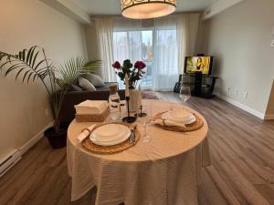 een woonkamer met een tafel met borden en wijnglazen bij Cé La Vie in Québec +5 foto's