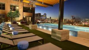 a large swimming pool with lounge chairs in a building at The Deep Ellum Serenity Suite in Dallas