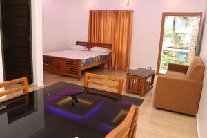 a room with a bed and a living room at Carmel Building in Marayoor +14 photos