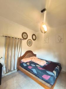 a bedroom with a bed and clocks on the wall at Little Loti Sikumana in Maulafa