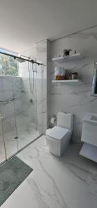 um banheiro branco com vaso sanitário e chuveiro em Bethel Home Sáchica minutes from Villa de Leyva em Sáchica