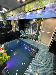 een zwembad in een kamer met een watervalmuurschildering bij Karachi Fort Boutique Hotel in Karachi +30 foto's