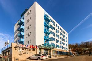 a building with a car parked in front of it at Hotel Marttel in Karlovy Vary