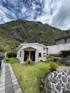 巴尼奥斯Magic Stone的一座小白色房子,后面有山