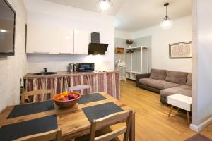 a kitchen and living room with a table and a couch at Baltic Design Apartments with free Parking and self check in in Rīga