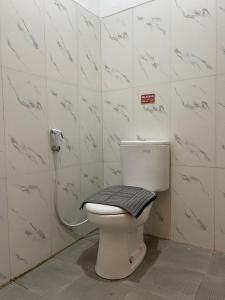 Baño con aseo y toalla en SM Guesthouse, en Blimbing 5 fotos más