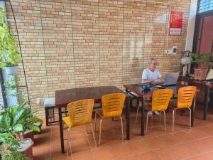 a man sitting at a table with a laptop at Villa 88 in Tân Thành (1)