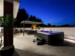 a hot tub on a patio at night at Villa Kate in Pašman