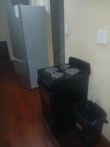 a black stove in a room with a refrigerator at Clark lodge at 272 in Durban