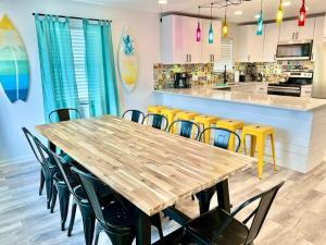 Sleeps 22, 2min Walk To The Beach, Heated PoolSpa في جنوب جزيرة بادري: مطبخ بطاولة خشبية وكراسي صفراء +37 صورة