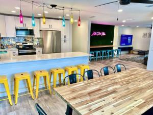 Sleeps 22, 2min Walk To The Beach, Heated PoolSpa في جنوب جزيرة بادري: مطعم بطاولة خشبية وكراسي صفراء