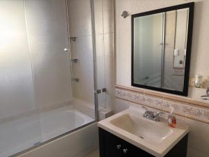 Un baño con lavabo y ducha con espejo. en Casa Nogales, en Ciudad Juárez 12 fotos más