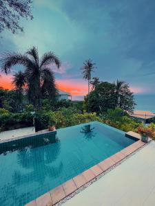 ein Swimmingpool mit einem Sonnenuntergang im Hintergrund in der Unterkunft SeaView Villa Tropicana in Salad Beach