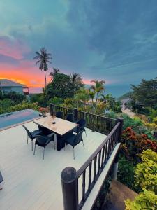 eine Holzterrasse mit einem Tisch und Stühlen darauf in der Unterkunft SeaView Villa Tropicana in Salad Beach + 25 Fotos