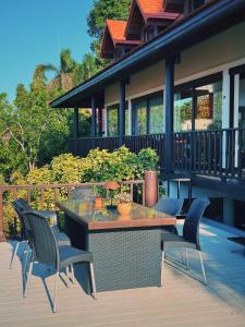 eine Terrasse mit Tisch und Stühlen auf einem Deck in der Unterkunft SeaView Villa Tropicana in Salad Beach