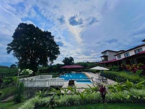 a swimming pool in front of a house at Hotel Campestre Jardín del Café Quindío in Armenia