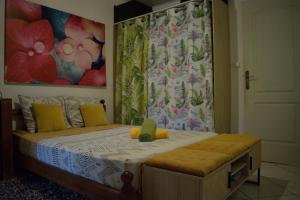 een slaapkamer met een bed met een schilderij aan de muur bij Le coin tranquille in Saint-Denis