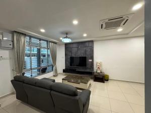 Una sala de estar con un sofá y un televisor. en 峇株巴辖皇子城现代简约风格民宿, en Tongkang Pechah