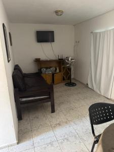 een woonkamer met een bank en een flatscreen-tv bij Hospedaje BellaVilla in Bell Ville