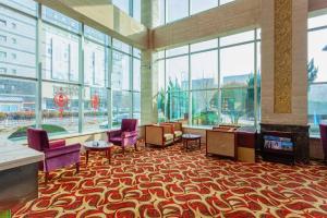 a lobby with chairs and a fireplace in a building at Qingdao Chengyang Detai Hotel in Qingdao