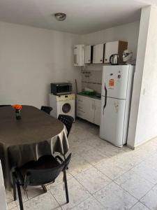 een kleine keuken met een tafel en een koelkast bij Hospedaje BellaVilla in Bell Ville