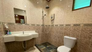 a bathroom with a toilet and a sink and a shower at Minang Cove Resort in Tioman Island +112 photos