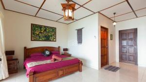 a bedroom with a bed with purple sheets and a ceiling at Minang Cove Resort in Tioman Island