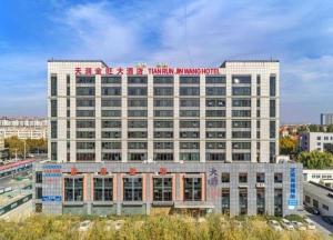 Qingdao TianRun JinWang Hotel في تشينغداو: مبنى كبير مع لافتة فوقه