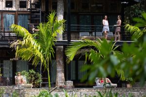 people on the balconies of a building with palm trees at Wild Monkey Jungle Villa - 4 Bedroom Villa in Unawatuna
