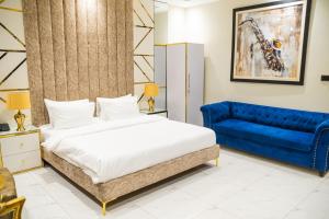 een slaapkamer met een bed en een blauwe bank bij Karachi Fort Boutique Hotel in Karachi