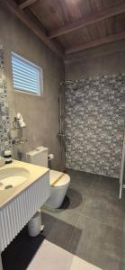 a bathroom with a toilet and a sink and a shower at Brizo Paradiso in Matara