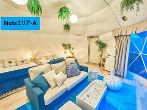 a living room with a couch and a bed in a room at リバーサイドグランピングNuts in Higashiomi