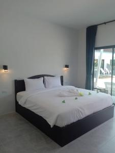 a bedroom with a large bed with white sheets at Naranta House in Ko Raeng