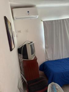 a small room with a bed and a tv at Hospedaje BellaVilla in Bell Ville