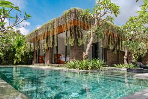 una villa con piscina frente a una casa en Kalapa and Merica Luxury Villas Ubud, en Gianyar