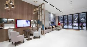 a living room with white chairs and a tv at Echarm Hotel Changde Chaoyang D5 District in Changde