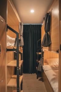 una piccola stanza con un letto e un letto a castello con le borse di Greet Hostel & Cafe Samyan a Bangkok