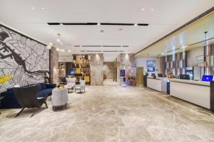 a lobby of a hotel with couches and chairs at Echarm Hotel Jingjiang Bus Passenger Station Fanggu Street in Jingjiang