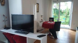 un salon avec une télévision sur une table blanche dans l'établissement Vila Ema Apartments and Rooms, à Ljubljana