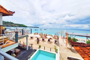 Una vista de la playa desde un balcón de un resort. en The Beach Huts Lembongan, en Nusa Lembongan