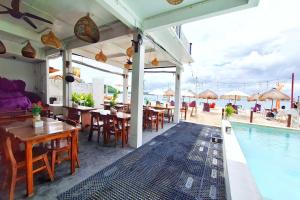 Un restaurante con mesas y sillas y una piscina. en The Beach Huts Lembongan, en Nusa Lembongan 17 fotos más